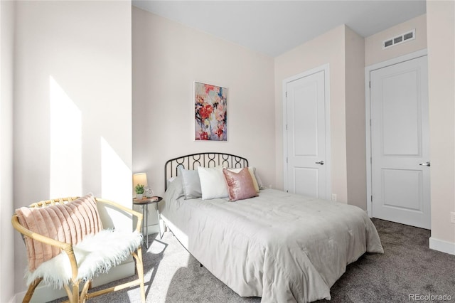 carpeted bedroom featuring baseboards and visible vents