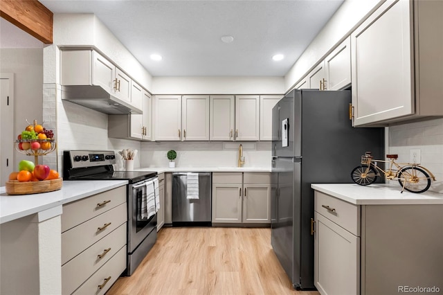 201 Wright St Unit 106, Lakewood, CO 80228 - kitchen with stainless steel appliances, a sink, light wood-type flooring, backsplash, and light countertops