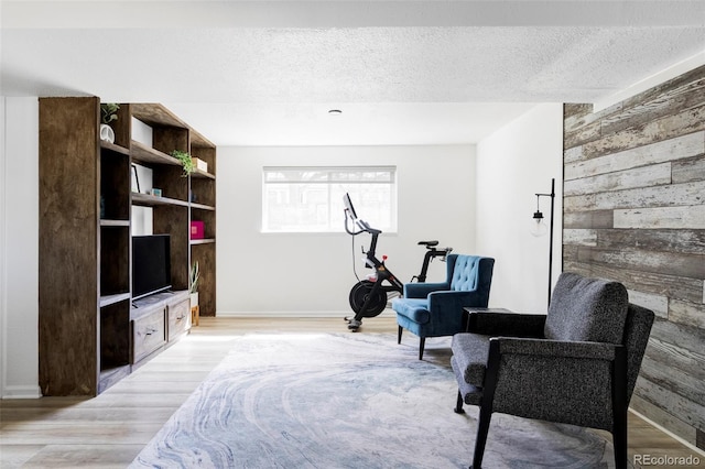 13055 E Dakota Ave, Aurora, CO 80012 - living area featuring light wood-type flooring, a textured ceiling, and wood walls