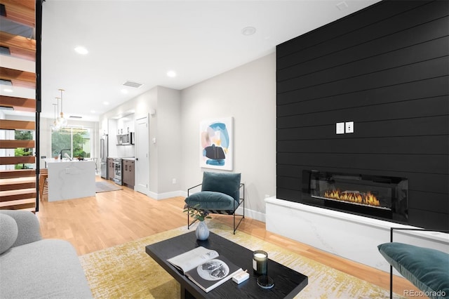 2179 S Bannock St, Denver, CO 80223 - living area with light wood-style floors, baseboards, a large fireplace, and recessed lighting