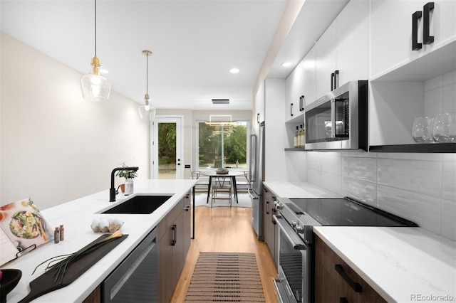 2179 S Bannock St, Denver, CO 80223 - kitchen featuring appliances with stainless steel finishes, a sink, light wood-style floors, recessed lighting, and white cabinets