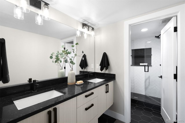 2179 S Bannock St, Denver, CO 80223 - full bath featuring double vanity, a stall shower, tile patterned floors, baseboards, and recessed lighting