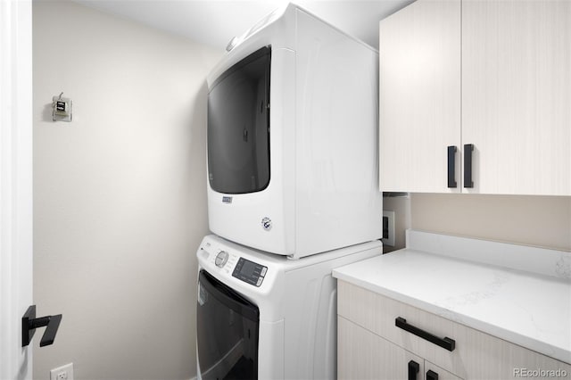 2179 S Bannock St, Denver, CO 80223 - washroom featuring stacked washing machine and dryer and cabinet space