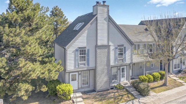 view of front of property featuring a chimney and a shingled roof