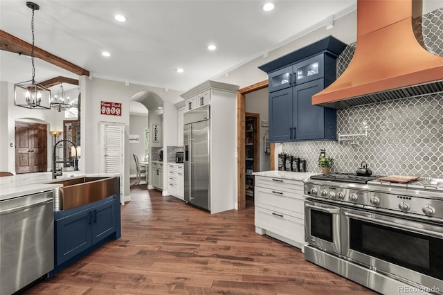 kitchen with premium range hood, decorative light fixtures, dark hardwood / wood-style flooring, sink, and high end appliances