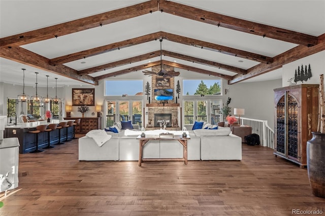 living room featuring a stone fireplace, dark hardwood / wood-style flooring, an inviting chandelier, high vaulted ceiling, and beamed ceiling