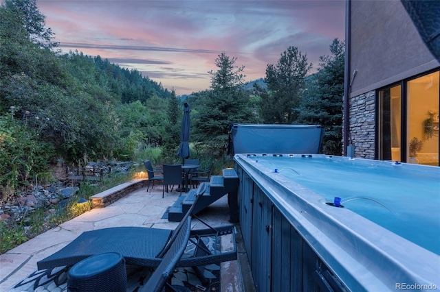 patio terrace at dusk with a hot tub