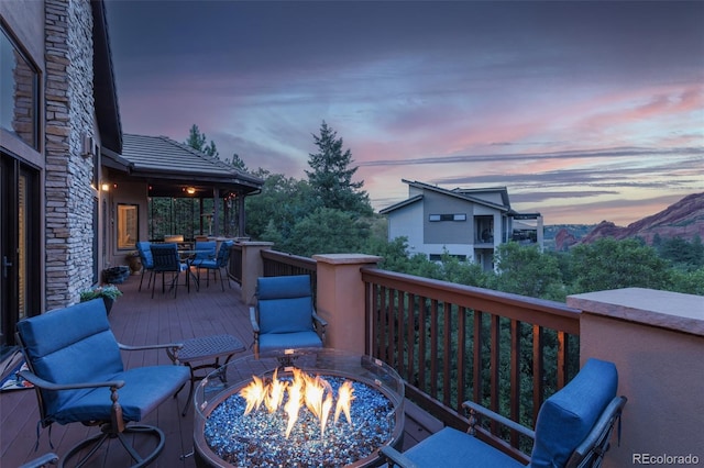 deck at dusk featuring an outdoor fire pit