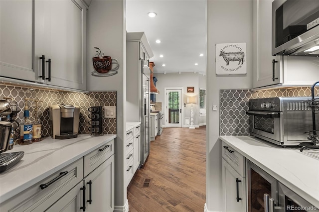 kitchen with gray cabinets, light wood-type flooring, and tasteful backsplash