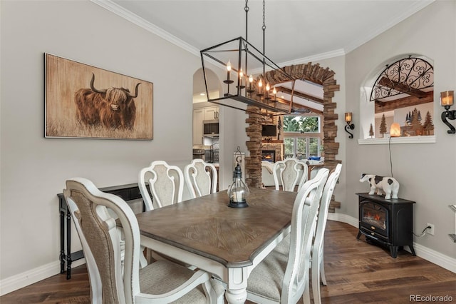 dining space with dark wood-type flooring, an inviting chandelier, and ornamental molding