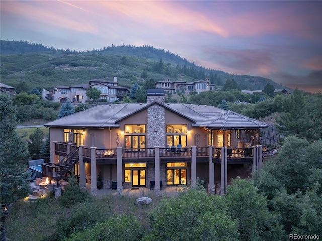 back house at dusk featuring a deck with mountain view