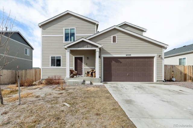 traditional-style house featuring concrete driveway and fence