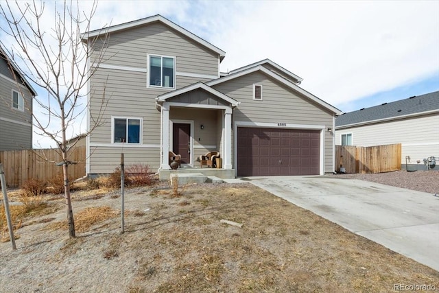 traditional-style home with a garage, fence, and driveway