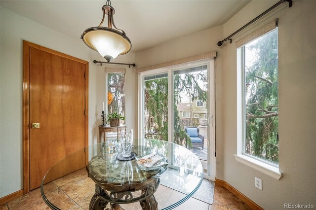 dining area featuring light tile patterned flooring, baseboards, and plenty of natural light
