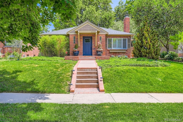 1224 Glencoe St, Denver, CO 80220 - view of front of house with a front lawn, brick siding, and a chimney