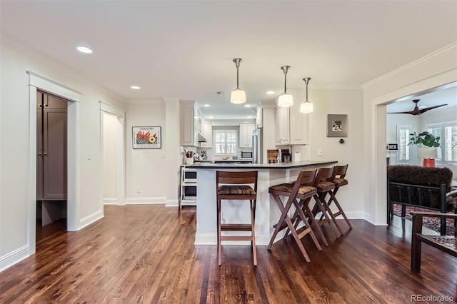 1224 Glencoe St, Denver, CO 80220 - kitchen featuring dark wood-type flooring, white cabinets, plenty of natural light, crown molding, and recessed lighting