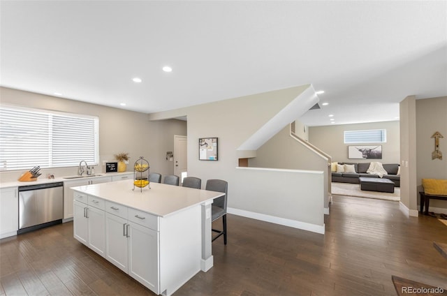 12845 Park Creek Way, Firestone, CO 80504 - kitchen with dishwasher, a breakfast bar, white cabinetry, light countertops, and a center island