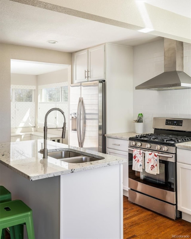 190 S Canosa Ct, Denver, CO 80219 - kitchen featuring wall chimney range hood, dark wood-style floors, decorative backsplash, and appliances with stainless steel finishes