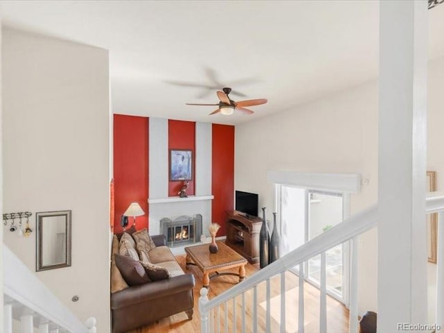 3914 E 116th Pl, Thornton, CO 80233 - living room with a ceiling fan, a lit fireplace, and wood finished floors