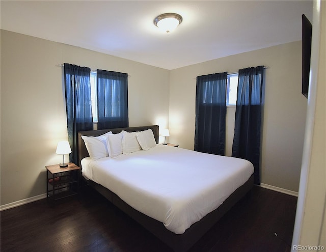 bedroom with dark wood-type flooring