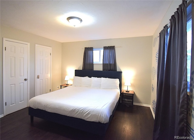 bedroom with dark hardwood / wood-style flooring