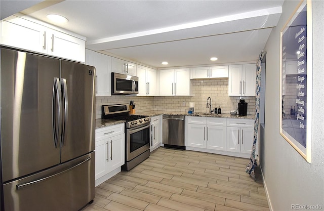 kitchen featuring stone countertops, white cabinetry, and stainless steel appliances