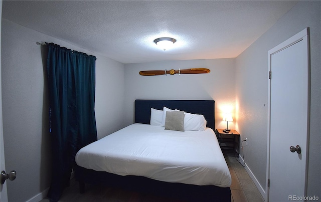 bedroom featuring wood-type flooring and a textured ceiling