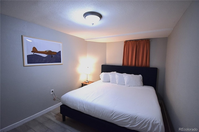 bedroom with hardwood / wood-style flooring and a textured ceiling