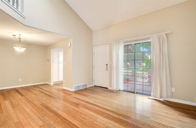 725 Crown Point Dr, Colorado Springs, CO 80906 - spare room featuring light wood-type flooring, high vaulted ceiling, baseboards, and a chandelier