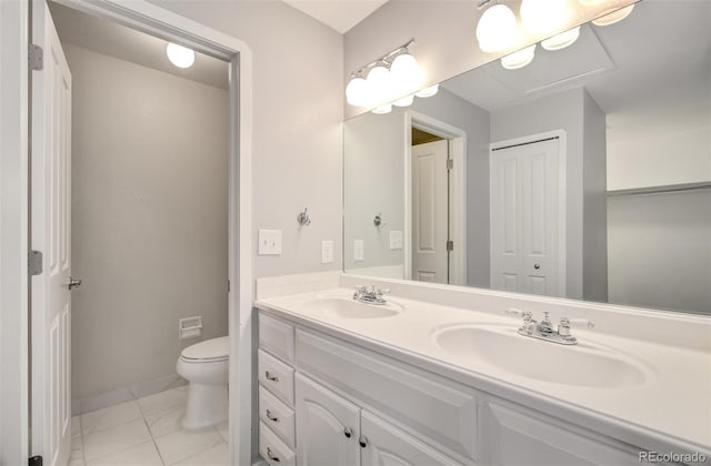 725 Crown Point Dr, Colorado Springs, CO 80906 - full bathroom featuring double vanity, toilet, baseboards, marble look tiles, and a closet