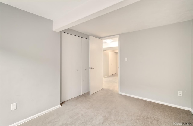 725 Crown Point Dr, Colorado Springs, CO 80906 - unfurnished bedroom featuring light carpet, a closet, and baseboards
