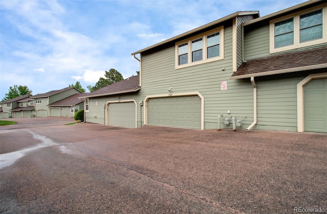 725 Crown Point Dr, Colorado Springs, CO 80906 - view of home's exterior with asphalt driveway, roof with shingles, and an attached garage
