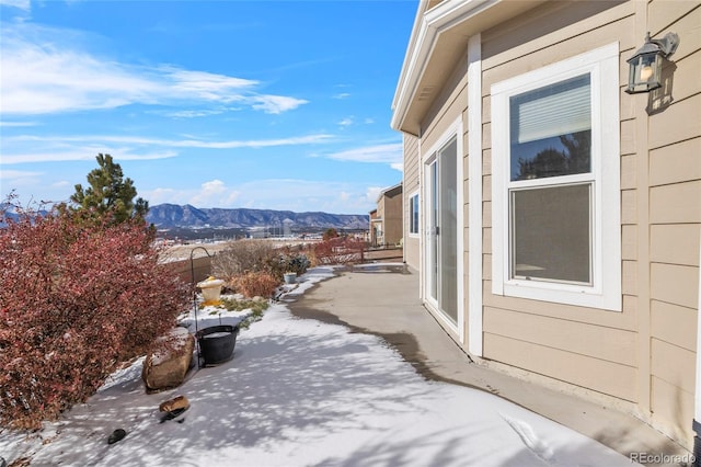 snow covered patio with a mountain view