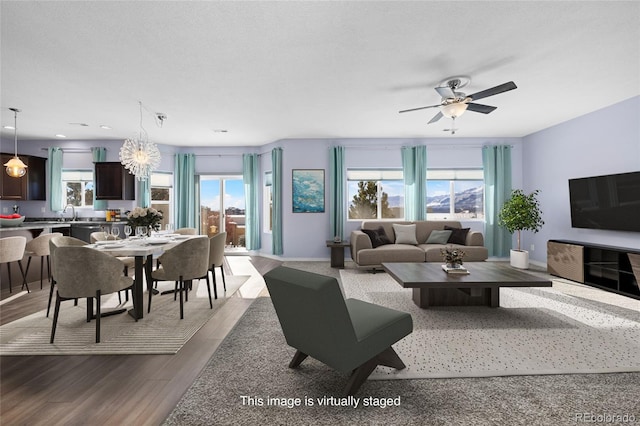 living room featuring light wood-type flooring, ceiling fan, a healthy amount of sunlight, and a textured ceiling