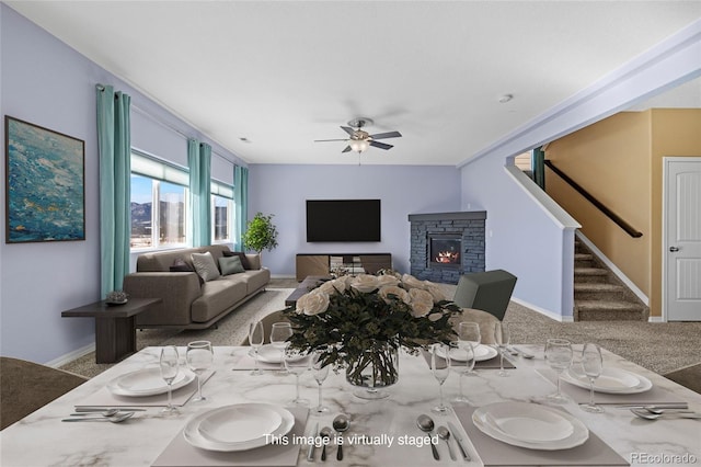 carpeted dining room featuring ceiling fan and a fireplace