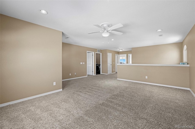 unfurnished room featuring ceiling fan, carpet, and washer / clothes dryer