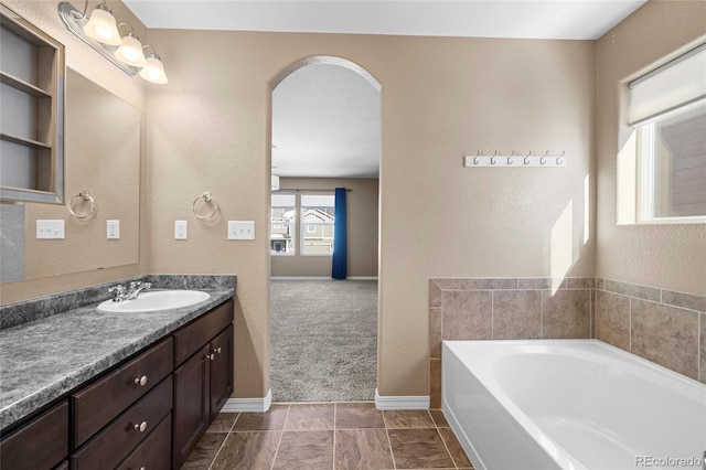 bathroom featuring a bath, tile patterned floors, and vanity