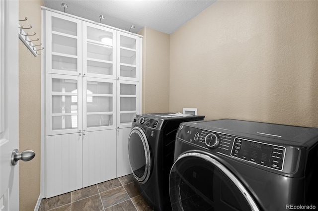 laundry area with a textured ceiling and washing machine and clothes dryer