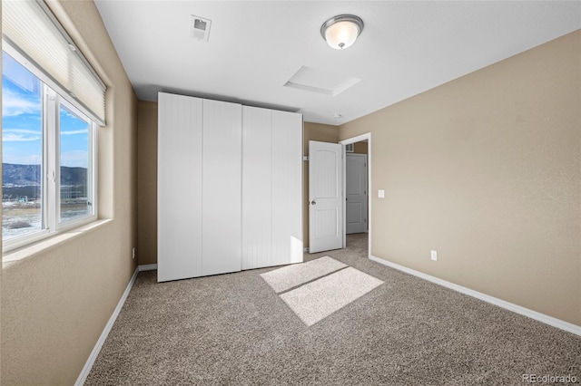 unfurnished bedroom with light carpet, multiple windows, and a mountain view