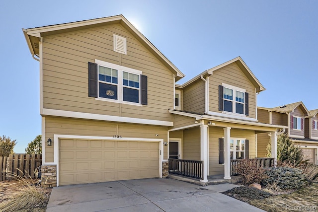 view of front of house featuring a porch, concrete driveway, an attached garage, fence, and stone siding