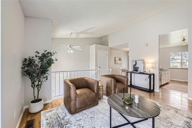 145 S Buchanan Ave, Louisville, CO 80027 - living room featuring lofted ceiling, wood finished floors, a textured ceiling, a ceiling fan, and baseboards