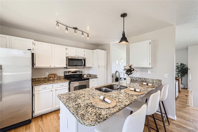 145 S Buchanan Ave, Louisville, CO 80027 - kitchen featuring stainless steel appliances, a sink, a peninsula, light stone countertops, and white cabinetry
