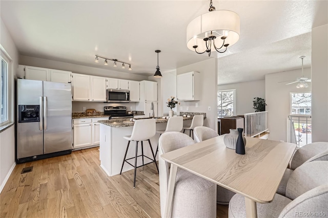 145 S Buchanan Ave, Louisville, CO 80027 - dining space featuring light wood-style flooring, a ceiling fan, a chandelier, and baseboards