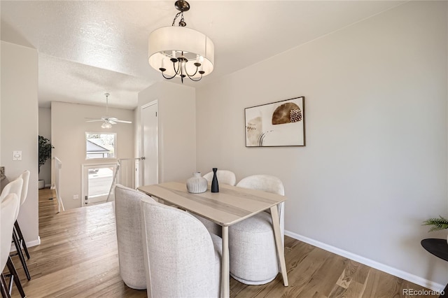 145 S Buchanan Ave, Louisville, CO 80027 - dining area featuring light wood finished floors, baseboards, a chandelier, and a ceiling fan