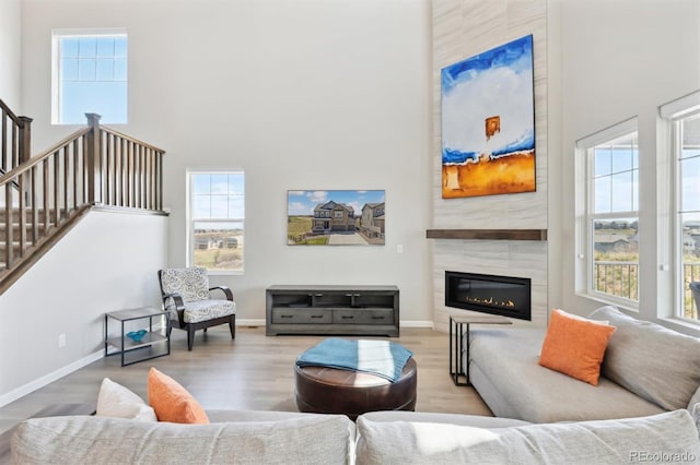 living area featuring a towering ceiling, baseboards, and plenty of natural light