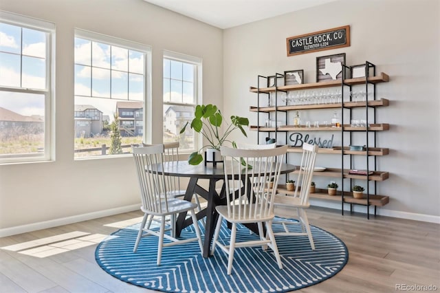 dining area with wood finished floors, baseboards, and a healthy amount of sunlight