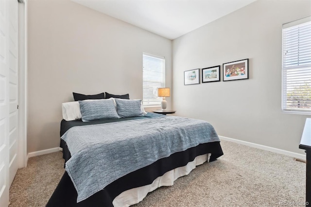 bedroom with baseboards, multiple windows, and carpet