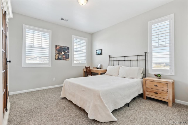 bedroom featuring light colored carpet, multiple windows, and baseboards