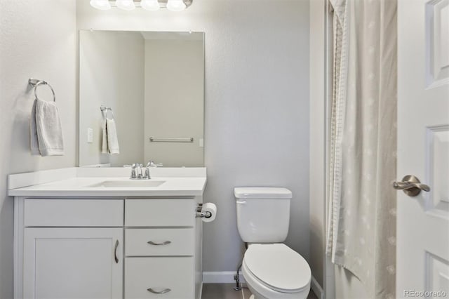 bathroom featuring curtained shower, vanity, and toilet