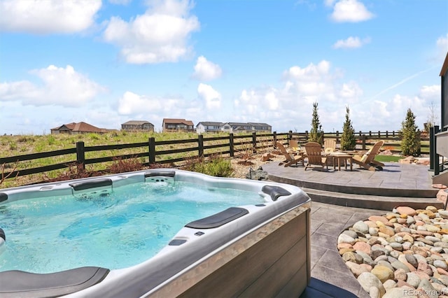 view of swimming pool featuring a patio area, a hot tub, fence, and a fire pit
